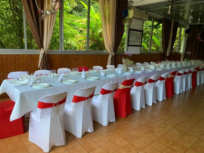 La grande salle de l'auberge, une longue table dressée face au jardin